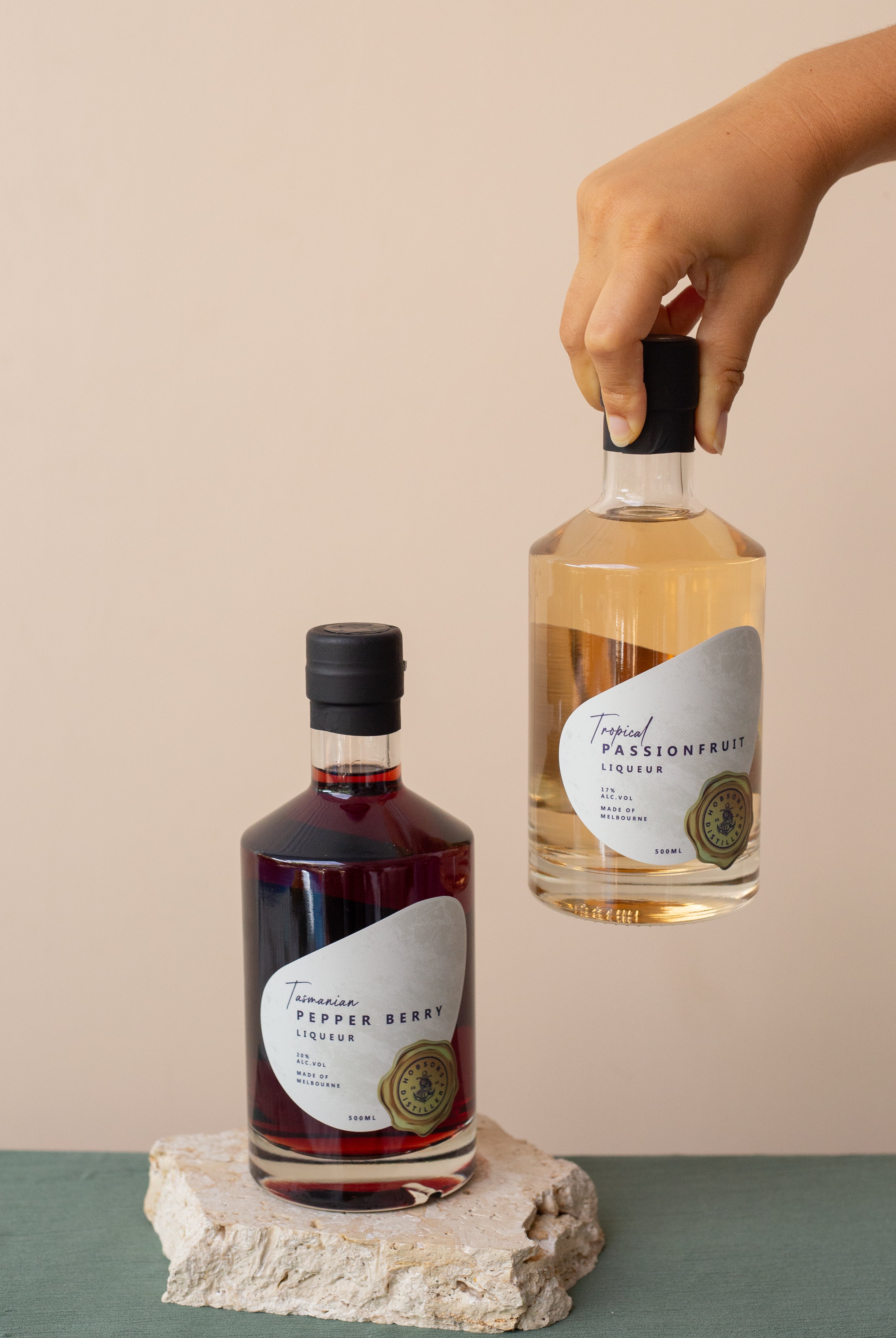 Two bottles of tropical-themed liqueurs on a neutral background