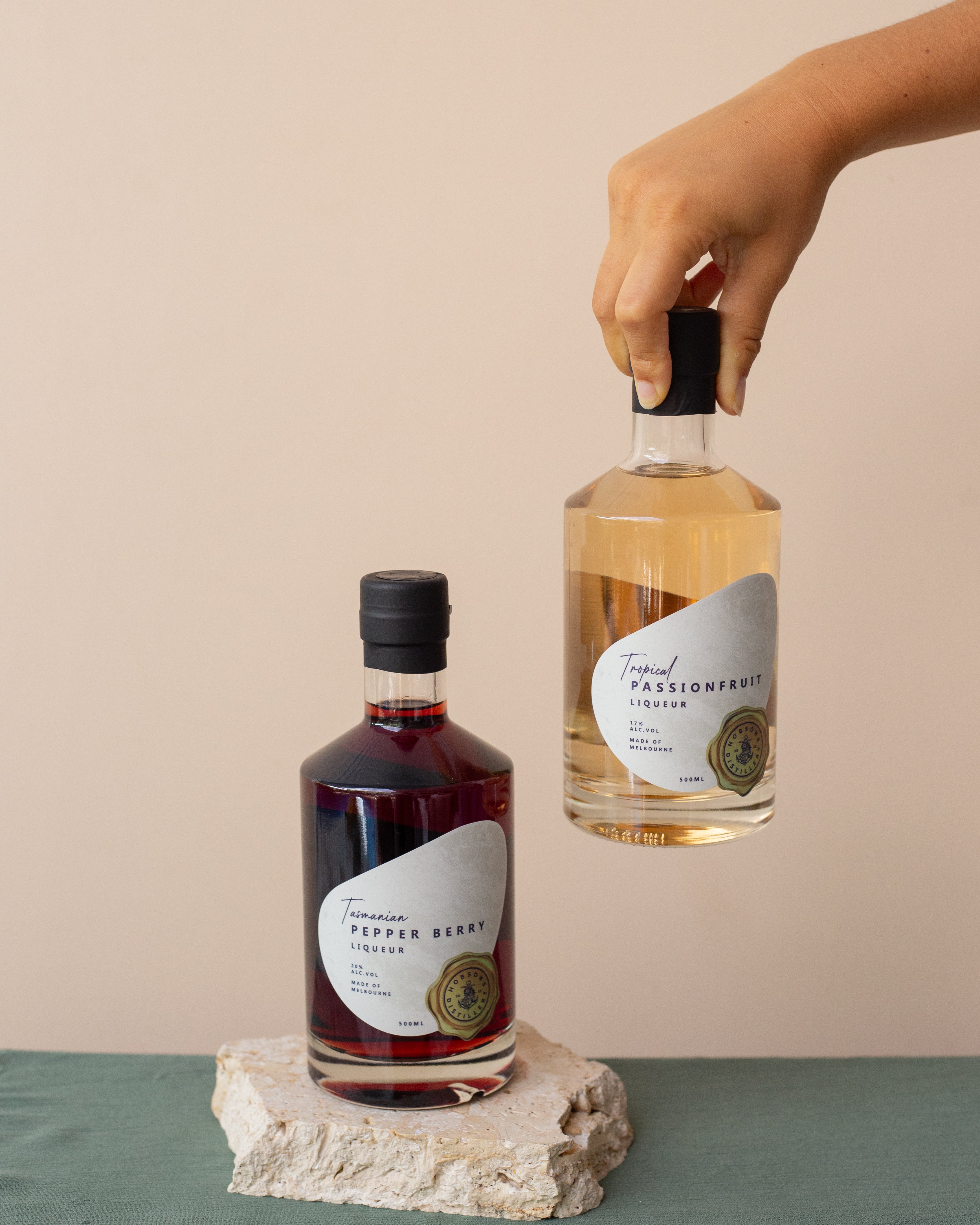 Two bottles of tropical-themed liqueurs on a neutral background