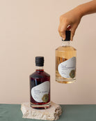 Two bottles of tropical-themed liqueurs on a neutral background